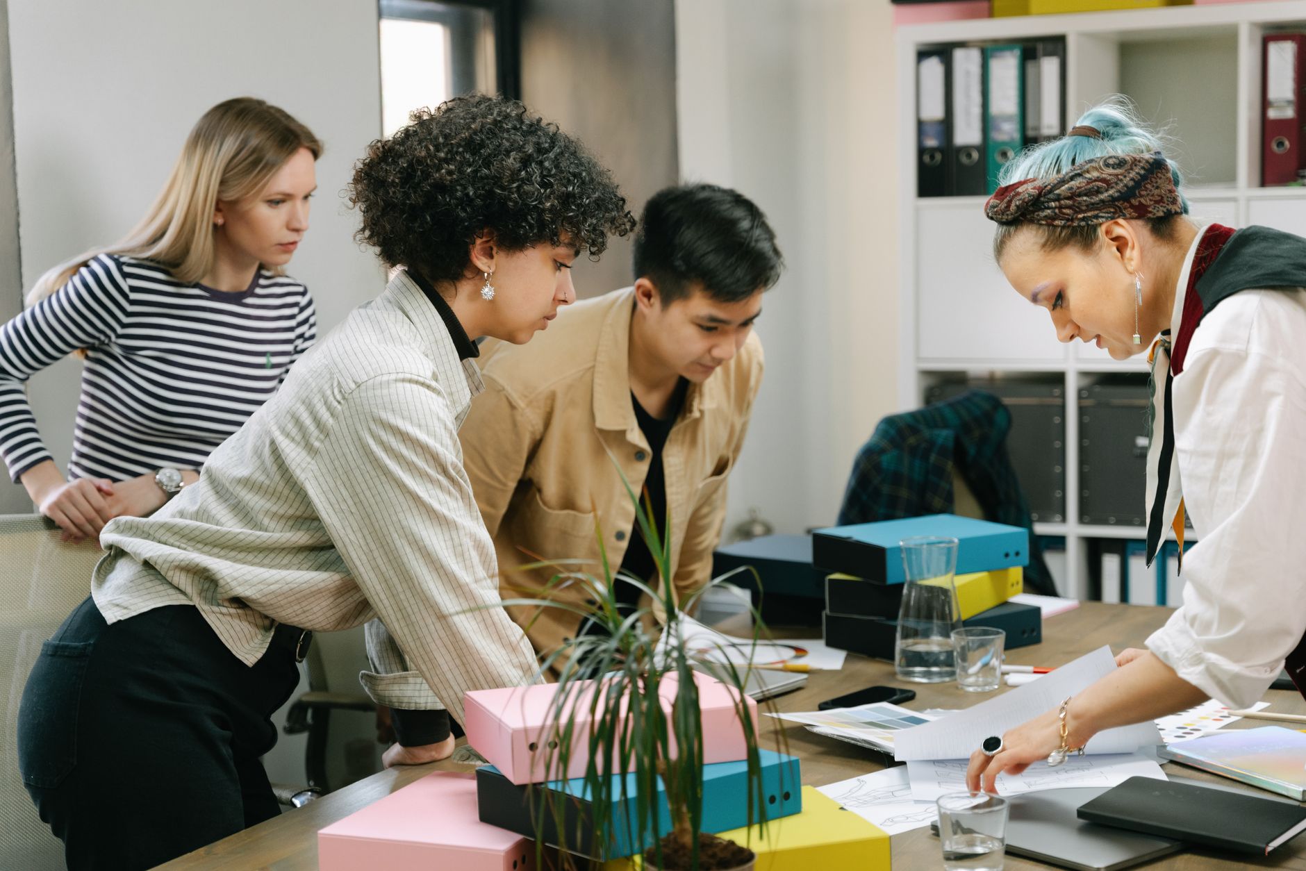 Collega's overleggen samen aan een tafel in een licht kantoor