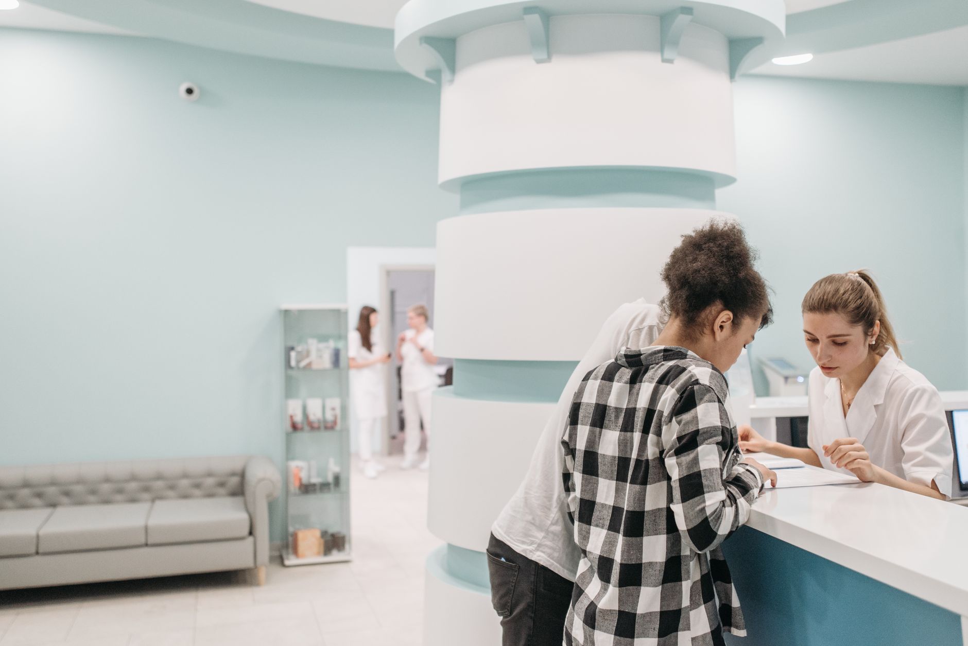 Medewerkers helpen bezoekers aan de balie van een moderne kliniek